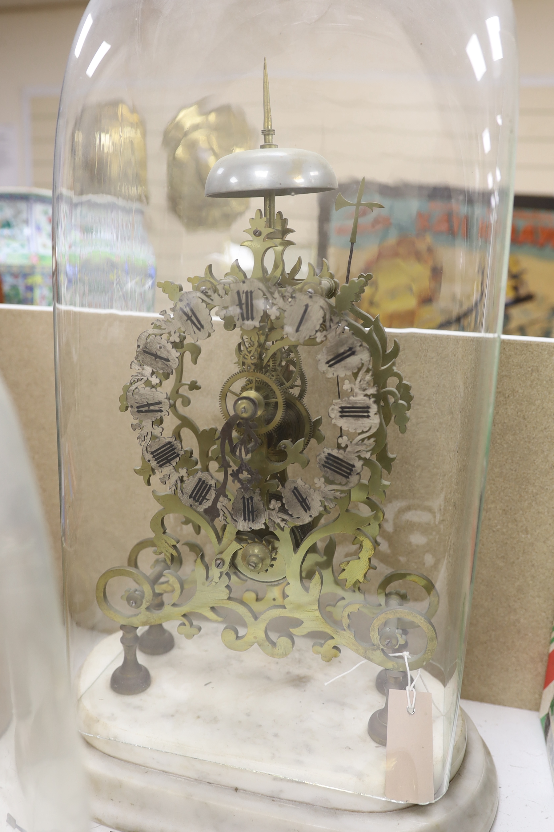 A Victorian skeleton clock and two glass clock domes